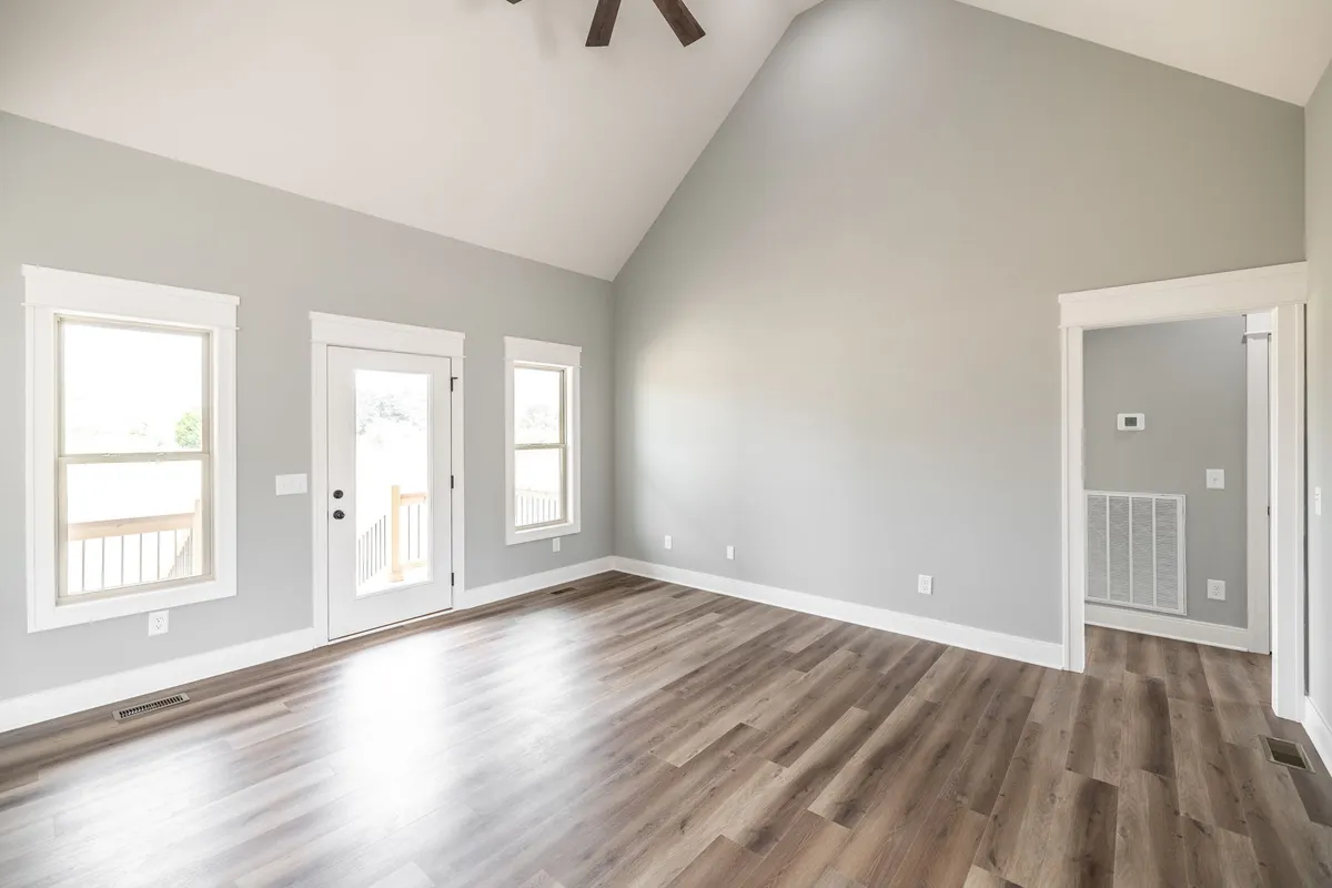 Vaulted living area with ceiling fan and large windows at 1200 Vickie Ln