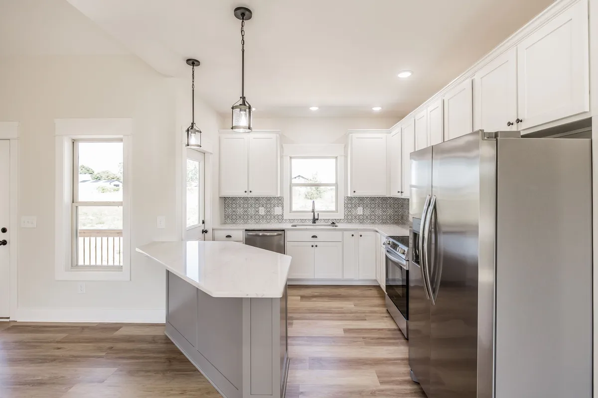 Kitchen island with pendant lighting and stainless steel appliances at 1204 Vickie Ln