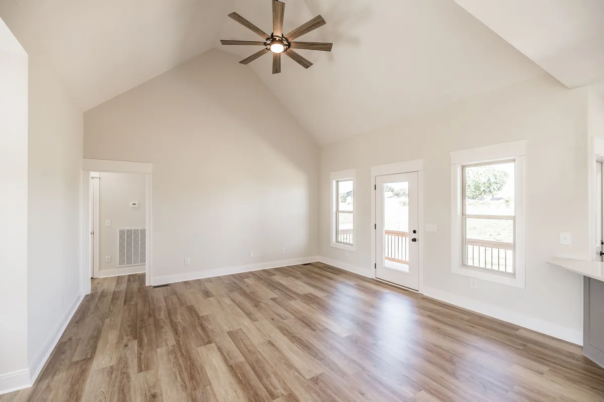 Vaulted great room with ceiling fan and large windows at 1204 Vickie Ln