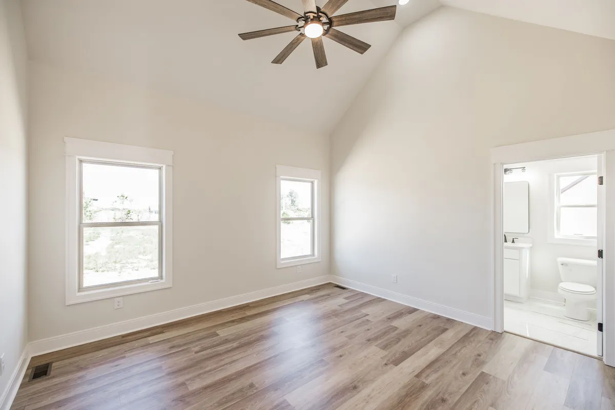 Spacious primary bedroom with vaulted ceiling and en-suite access at 1204 Vickie Ln