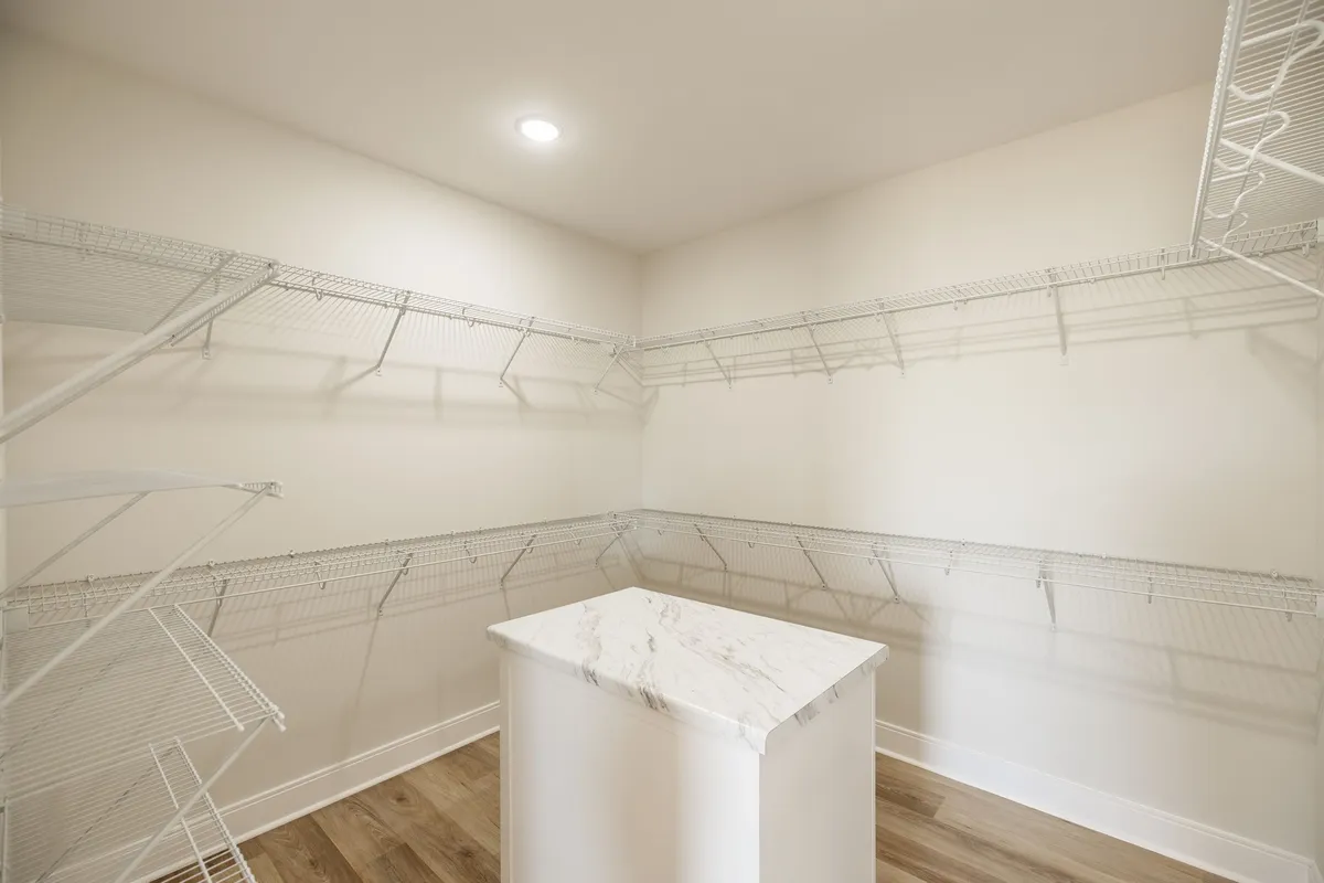 Walk-in closet with built-in shelving and a window at 1204 Vickie Ln