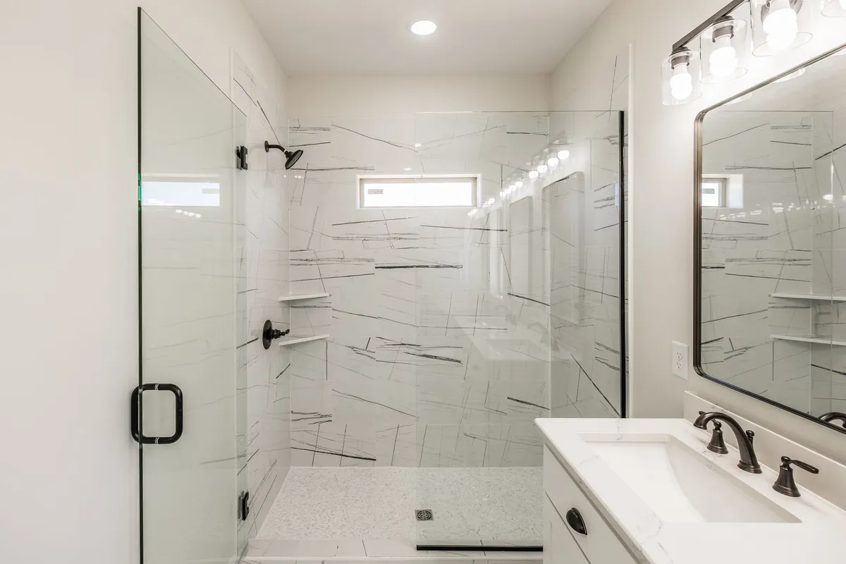 Tiled walk-in shower with a glass door in the primary bath at 1204 Vickie Ln