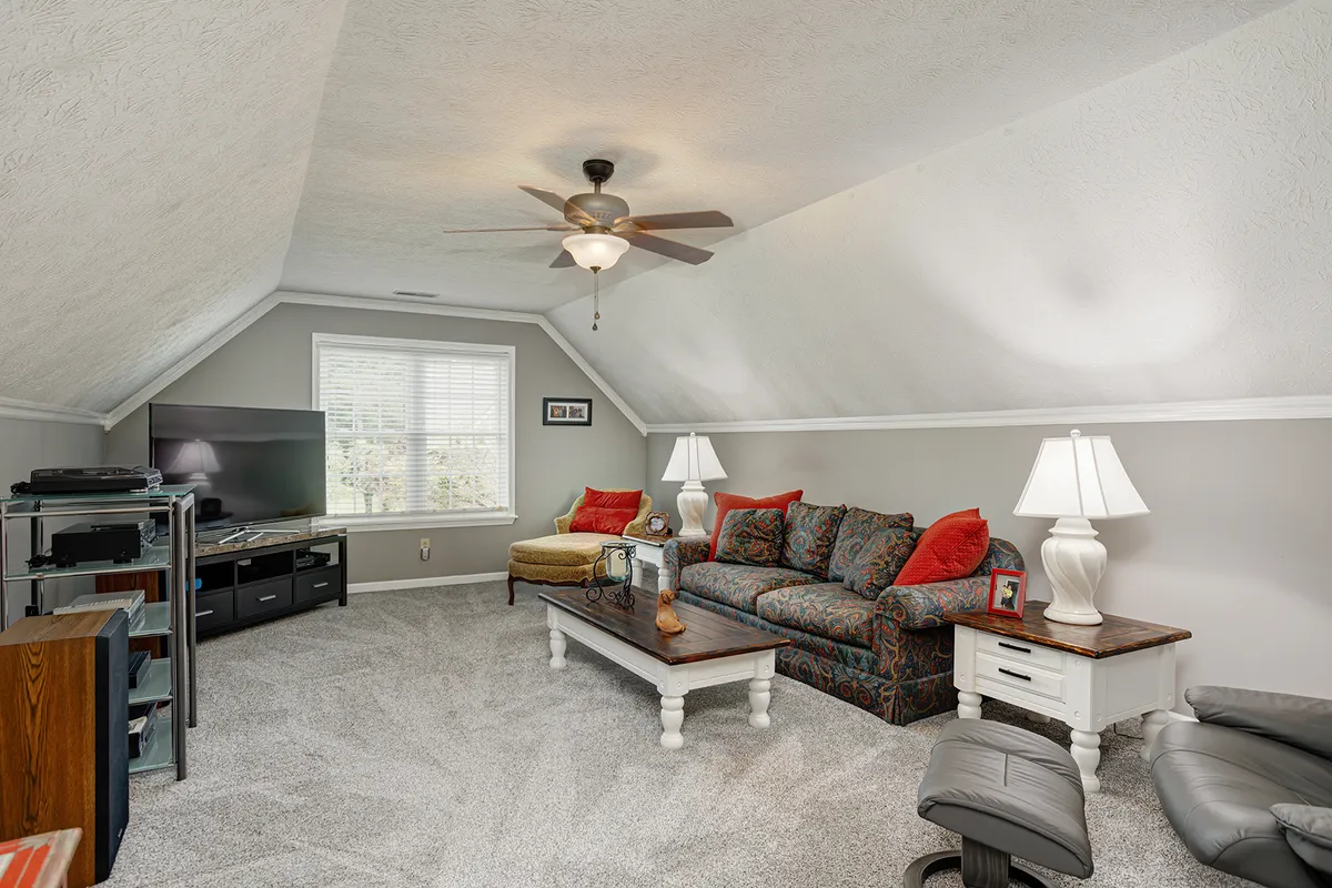 Second bedroom with a ceiling fan and updated carpet at 129 Baldridge Dr