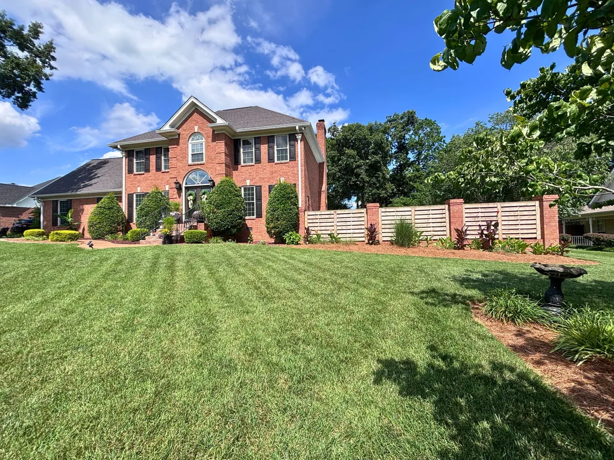 Front exterior of 129 Baldridge Dr, a two-story brick traditional with a manicured lawn in Cottontown TN