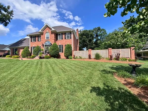 Front exterior of 129 Baldridge Dr, a two-story brick traditional with a manicured lawn in Cottontown TN