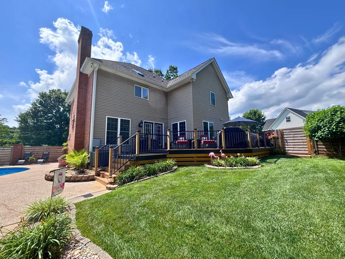 Rear exterior with a new deck, in-ground pool, and privacy fence at 129 Baldridge Dr