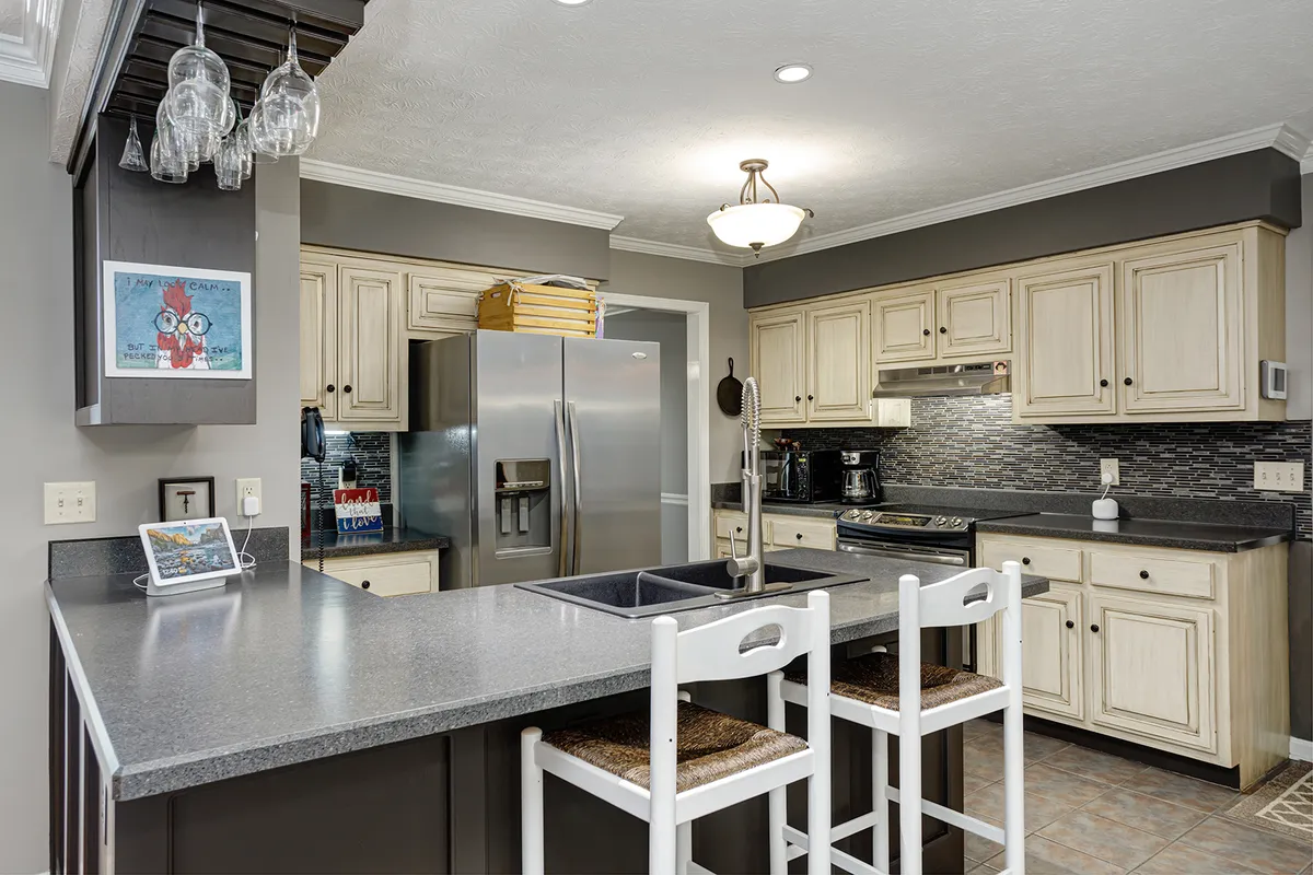 Kitchen with white cabinetry, stainless appliances, and a center island with bar seating at 129 Baldridge Dr