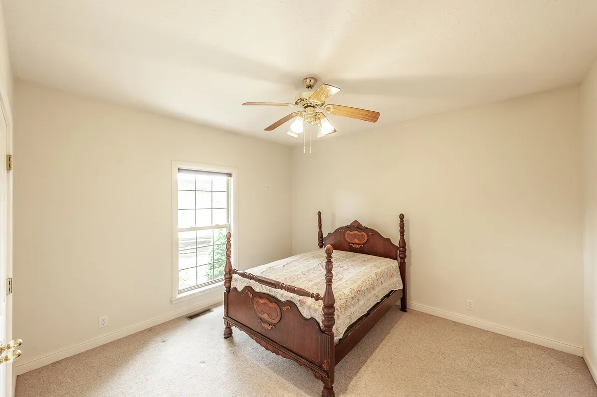 Second bedroom with a ceiling fan and natural light at 6513 N Mount Pleasant Rd