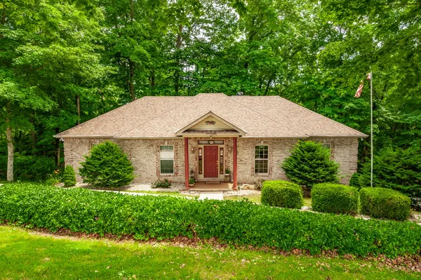Front exterior of 6513 N Mount Pleasant Rd, an all-brick ranch on a private wooded lot in Greenbrier TN